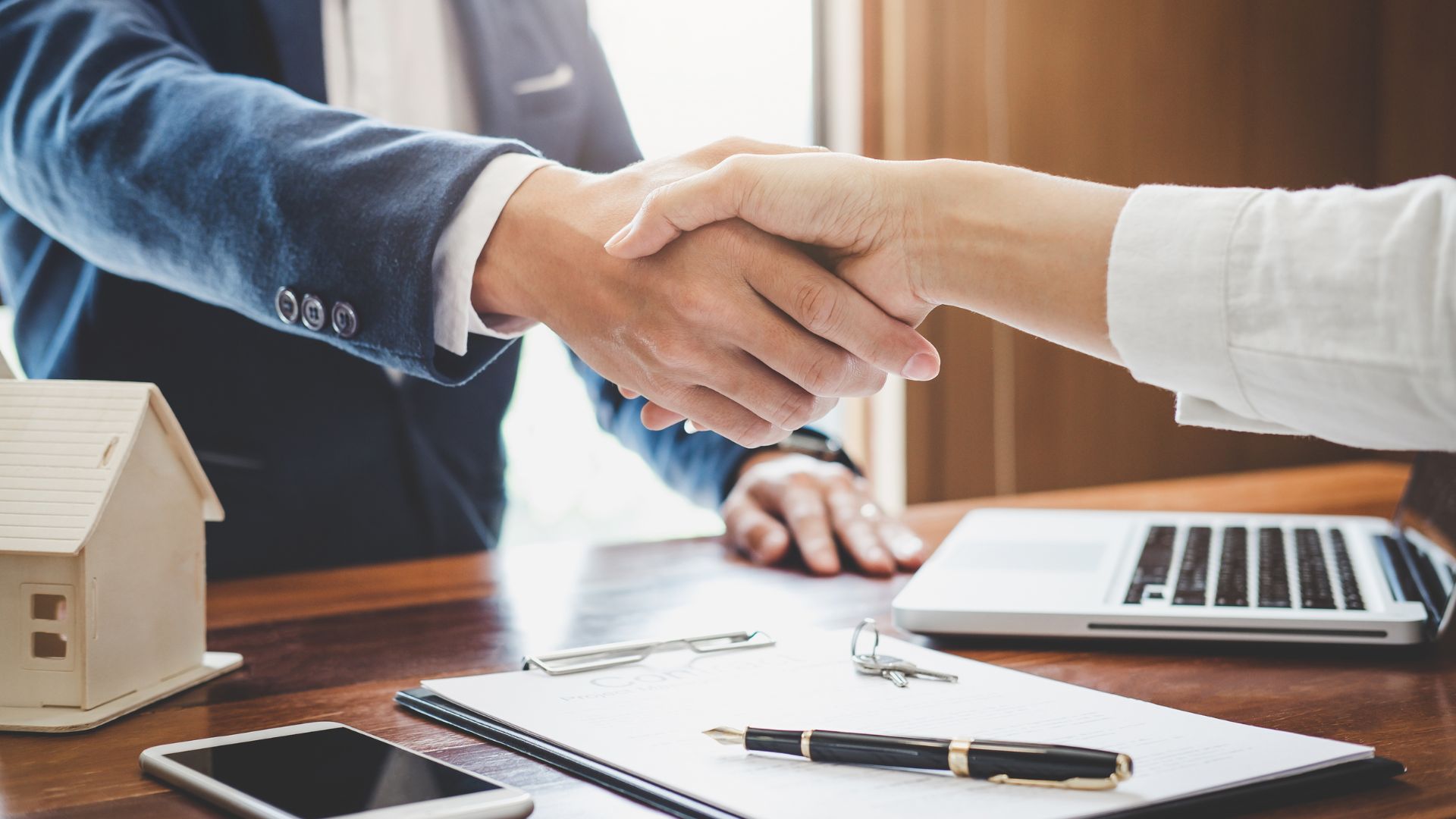 Insurance Agent Handshaking With Client